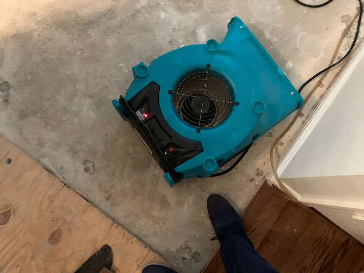 Air mover drying subfloor during Commercial Water Damage Restoration in North Versailles